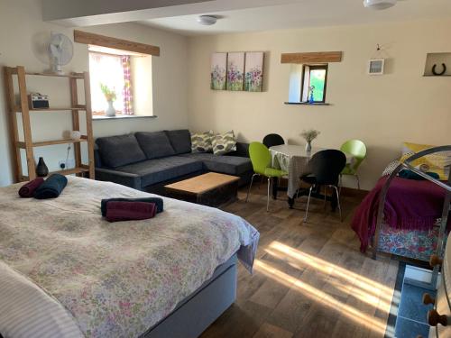 a bedroom with a bed and a couch and a table at The Shippon at RoseHip in Launceston