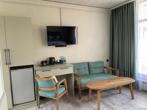 a room with a desk and a chair and a table at Kausar Hotel in Bishkek