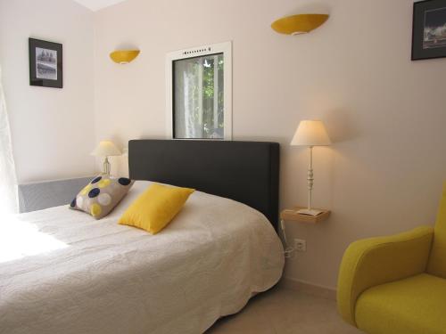 - une chambre avec un lit et une chaise jaune dans l'établissement Casa Rurale Lou Pichoun Nis, à Belcodène