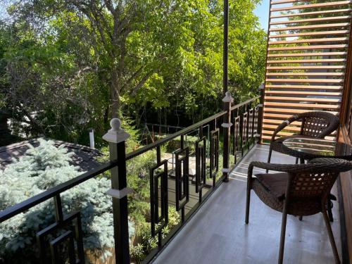 a balcony with two chairs and a table on it at Kausar Hotel in Bishkek