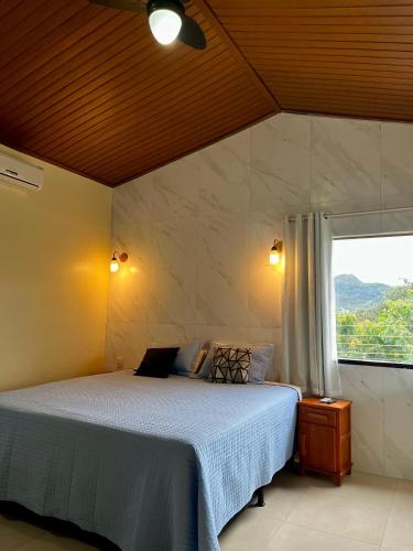 a bedroom with a large bed and a window at Pousada do Irlandês in Pirenópolis