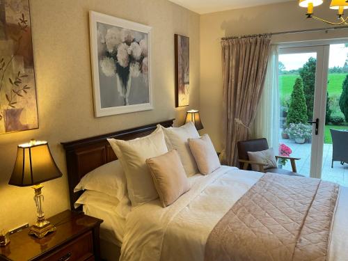 a bedroom with a bed with white sheets and pillows at Crowfield Country House in Aghadowey