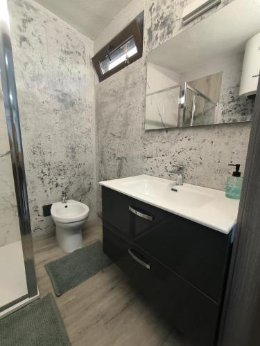 a bathroom with a sink and a toilet at Villa Topaz in Capoterra