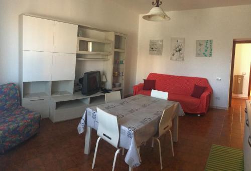 マンチャーノにあるCasa Vacanze Elisaのリビングルーム(テーブル、赤いソファ付)