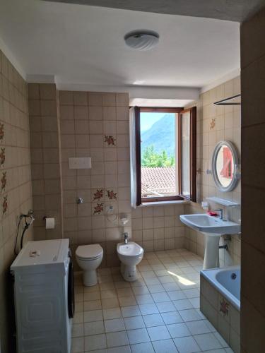 a bathroom with a sink toilet and a window at Appartamento Felis in Molina di Ledro