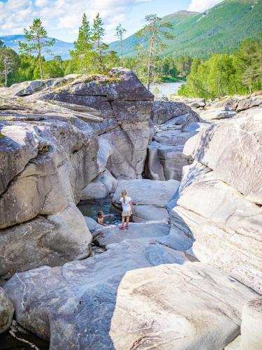 two children are standing on the rocks in a canyon at Krokstrand Fjellpark AS in Storforshei