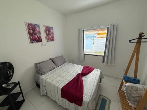 a small bedroom with a bed and a window at Mar Azul Beach House in Cabo Frio