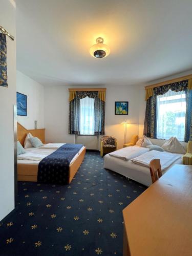 a hotel room with two beds and a table at Hotel Bayrischer Hof in Wels