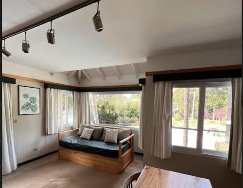 a bedroom with a bed and a large window at Miradores del Bosque Apart & Spa in Mar de las Pampas