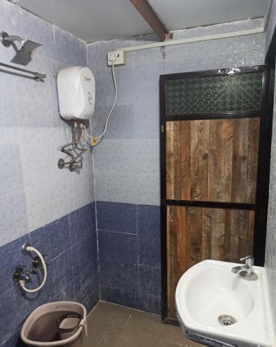 a bathroom with a sink and a toilet and a shower at Caffe Bombay in Nagaon