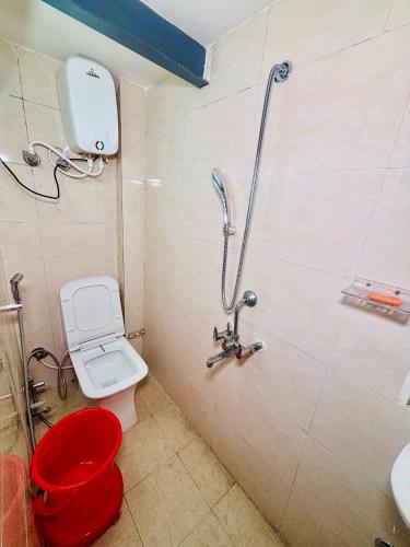 a bathroom with a red toilet and a shower at Nirvana Homestay in Mathura