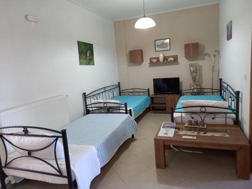 a room with two beds and a coffee table at Myrina View in Myrina