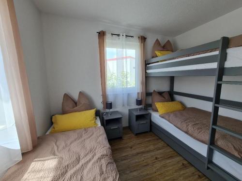 a bedroom with two bunk beds and a window at Campingpark Rammingen in Rammingen