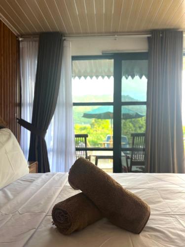 a towel laying on top of a bed with a window at Sun Grace Villa and Camp in Sembalun Lawang