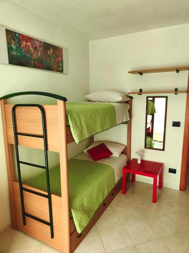 a bedroom with two bunk beds and a red table at Golden Hour House in Termoli