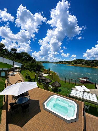 a patio with a swimming pool and an umbrella at Surreal Igaratá Pousada in Igaratá