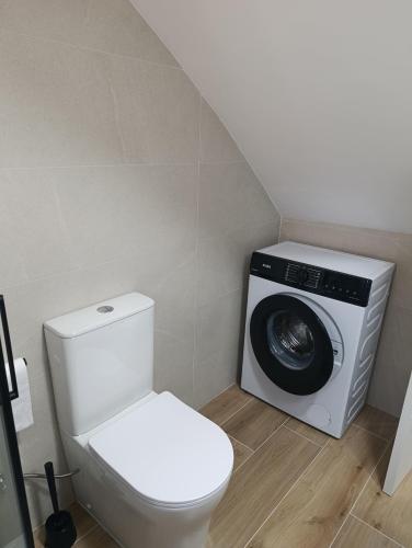 a bathroom with a toilet and a washing machine at APARTAMENTOS MATARRANYA in Valderrobres
