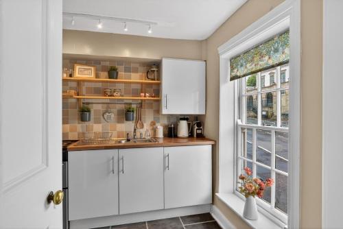 a kitchen with white cabinets and a window at Castleview in Hillsborough
