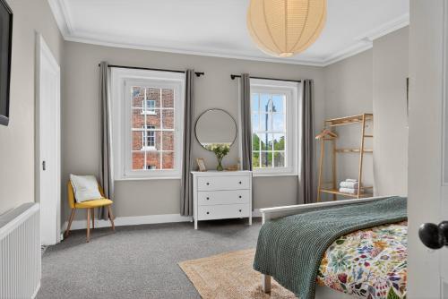 a bedroom with a bed and a mirror and a chair at Castleview in Hillsborough