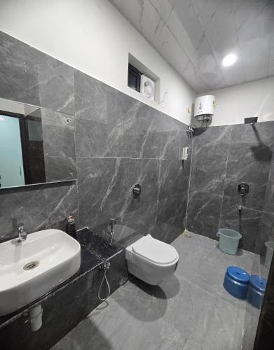a bathroom with a sink and a toilet at Rainbow Cottage Stays in Kānha