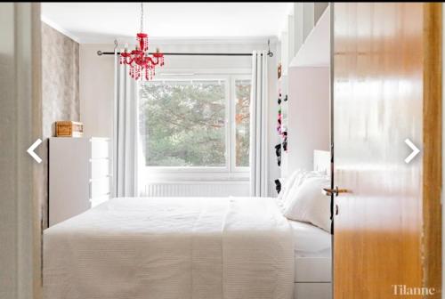 a bedroom with a white bed and a window at Tina's Apartment in Pori