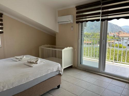 a bedroom with a bed and a large window at mavikösk apartement in Dalyan
