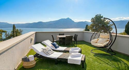 a balcony with a table and chairs and a swing at Ca Bosca - Fine Living in Torri del Benaco