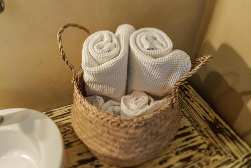 a basket filled with towels on a counter next to a sink at Dimora Ferraris in Càbras