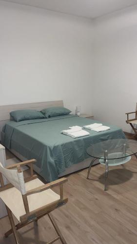 a bedroom with a bed and a glass table and a chair at Casa Vacanza Giorgio Apartment in Gallarate