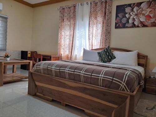 a bedroom with a large wooden bed in front of a window at Immanuel Victory hotel in Atebubu