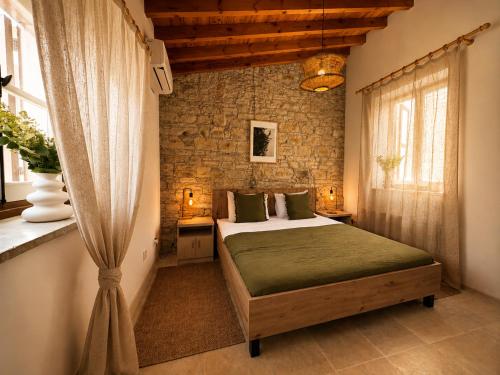 a bedroom with a bed and a brick wall at Four Stories Lefkara in Pano Lefkara