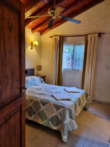a bedroom with a bed with a ceiling fan at Cabanias El Aguaribay in San Javier