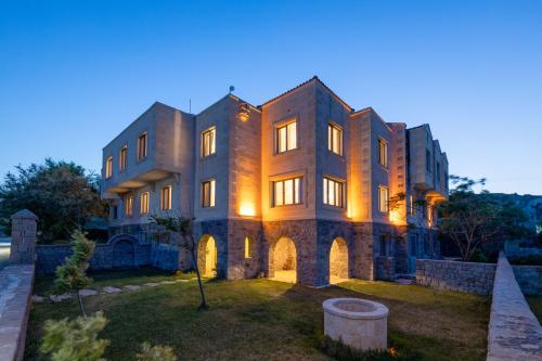 a large brick building with its lights on at Cinarli Kasri in Gokceada Town