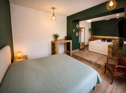a bedroom with a large bed and a bathroom at Gîtes de la Renaissance in Merlieux-et-Fouquerolles