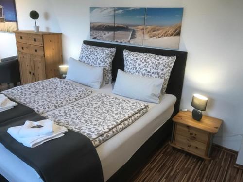 a bedroom with a bed with a black and white comforter at Gästehaus Zur Linde in Otterndorf