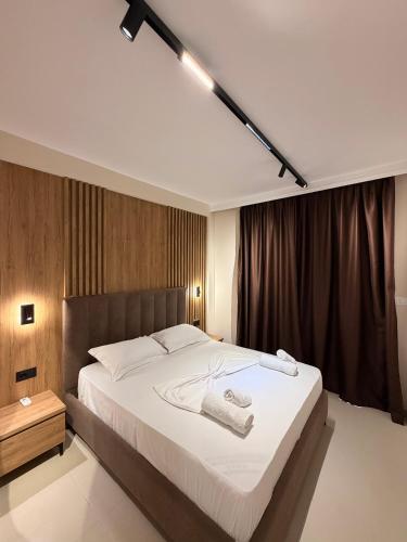 a bedroom with a large white bed in a room at Vila Llaman Luxury Rooms in Himare