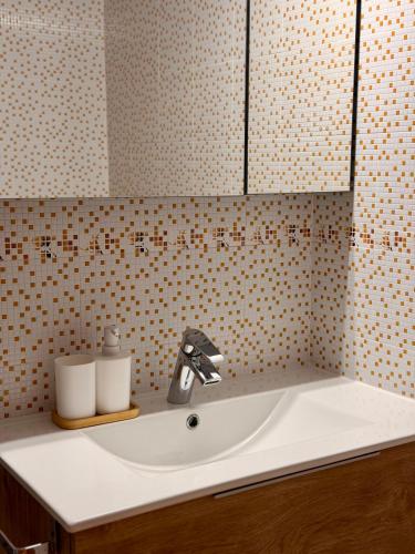 a sink in a bathroom with a tiled wall at Monte Subiedes, Apartamentos Valle de Camaleño in Camaleño