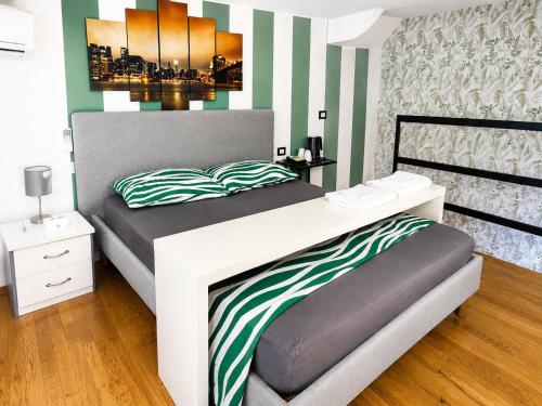 a bedroom with a bed with green and white stripes at Milano Brenta Suites Room for 2 in Milan