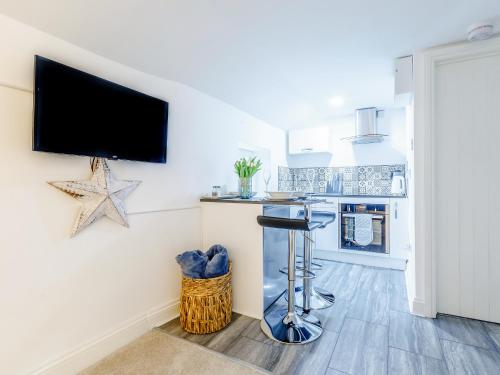 a kitchen with a bar and a tv on a wall at Lake View-Uk34414 in Cheddar