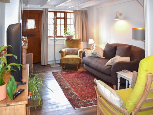 a living room with a couch and a chair at Little Hog Cottage in Seaton