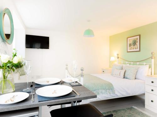 a bedroom with a bed with two white plates on a table at Meadow View-Uk34416 in Cheddar