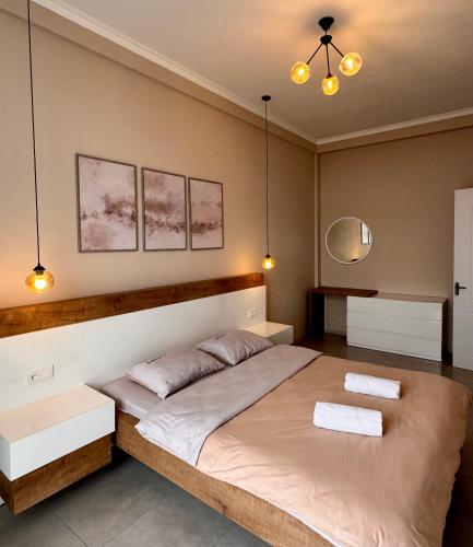 a bedroom with a large bed with two towels on it at Kutaisi Glow in Kutaisi