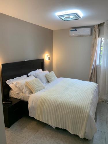 a bedroom with a large bed with white sheets at Modern 1bedroom apartment in Douala