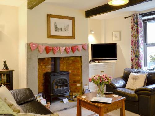 a living room with a fireplace and a couch at Park View Cottage in Old Glossop
