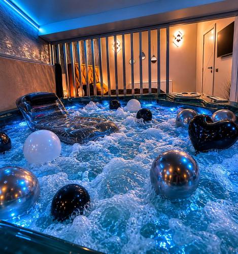 a jacuzzi hot tub with balls in it at Luxor - Private Jacuzzi Boulevard Suites in Sibiu