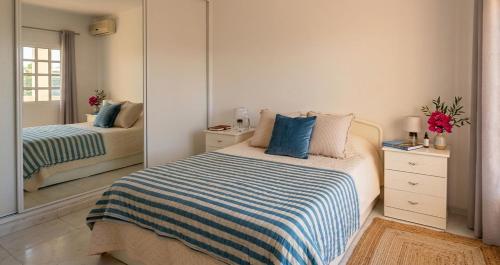 a bedroom with a bed and a mirror at Casa Nuno in Lagoa
