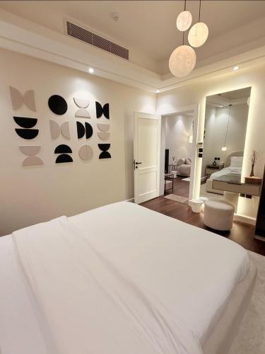 a white bedroom with a white bed and a room at Luxury apartment jeddah in alrawdah 6 Near the airport in Jeddah