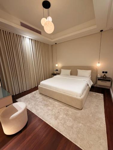 a bedroom with a large white bed and a stool at Luxury apartment jeddah in alrawdah 6 Near the airport in Jeddah
