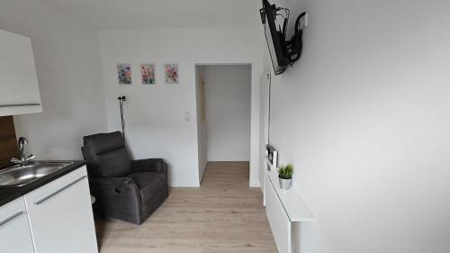 a living room with a black chair in a kitchen at Schönes Apartment in Verl in Verl