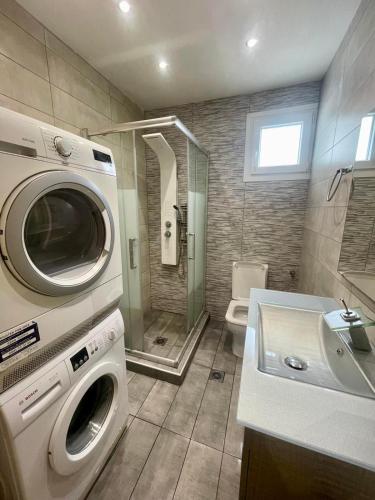 a bathroom with a washing machine and a sink at Tsoukanas Studios in Patitiri